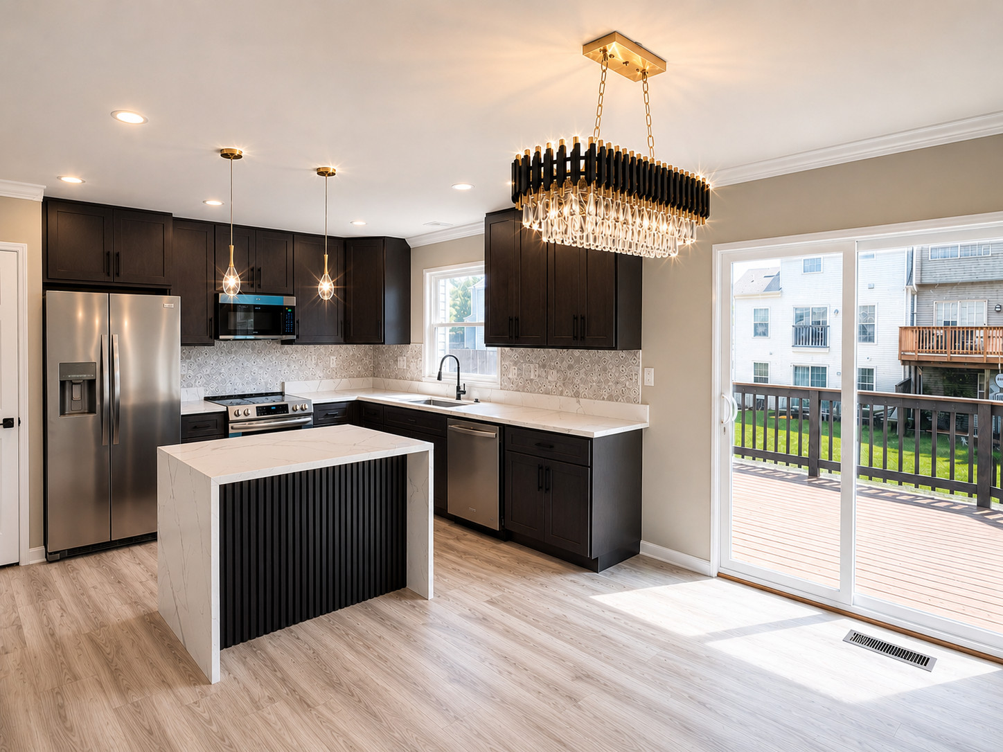 Professionally photographed renovated kitchen with dark cabinetry and statement lighting